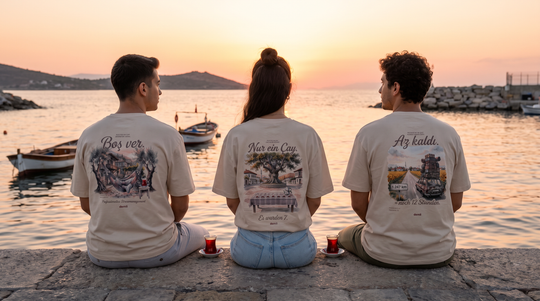 Drei Freunde in demli Shirts auf einer Hafenmauer an der Ägäis