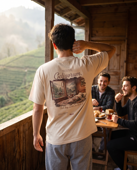 Mann im demli Geliyorum. Shirt in Sand von hinten auf einer Holzveranda am Morgen