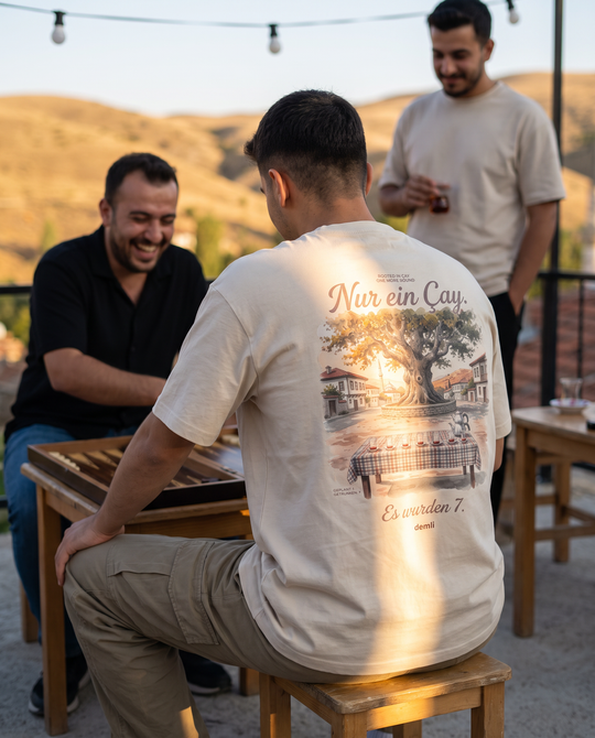 Mann im demli Nur ein Çay. Shirt in Sand von hinten beim Tavla mit Freunden