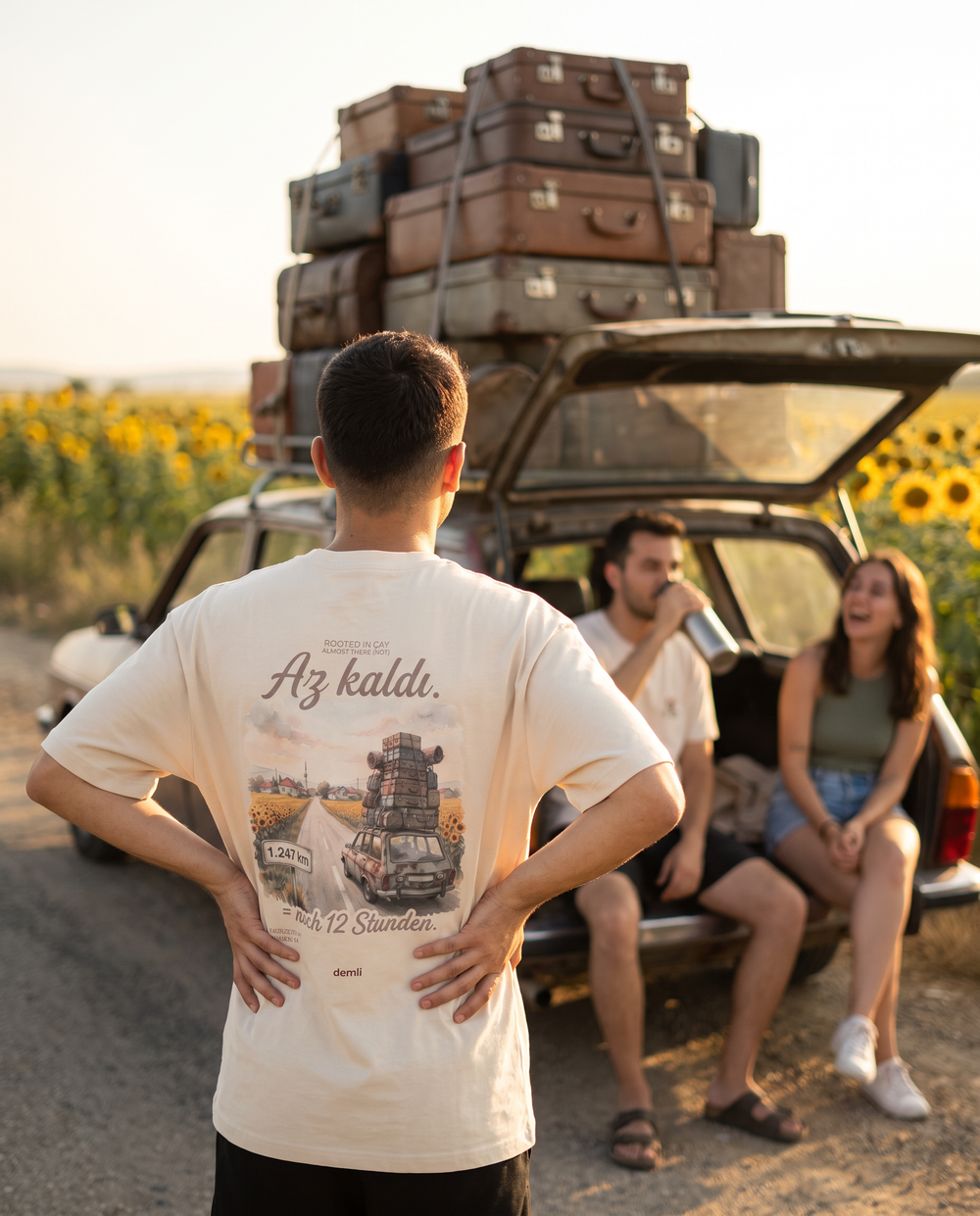 Mann im demli Az kaldı. Shirt in Sand von hinten am Rastplatz neben einem bepackten Auto